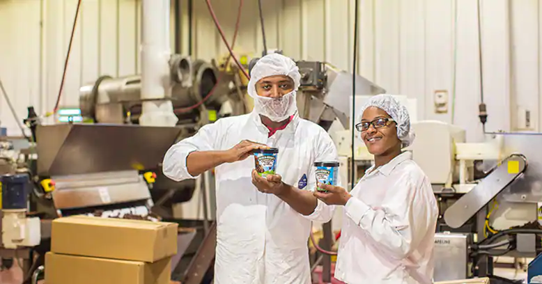 2 factory workers holidng ice cream tubs